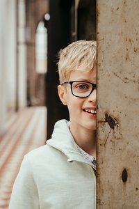 portret van jongen in oud gebouw waarbij de helft van zijn gezicht verstopt zit achter een stalen pilaar-communie-lentefeest-groeifeest-vormsel-portretfotografie-by Fotografils-Ilse Wagemakers-fotograaf in Essen