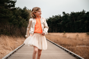 meisje huppelt op een vlonder door het natuurgebied-lentefeest-communie-groeifeest-kinderfotografie-Fotografils-by Ilse Wagemakers-fotograaf-Kalmthoutse heide