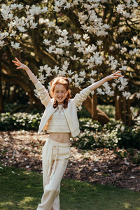 vrolijk portret van meisje met armen hoog in de lucht bij magnoliabloesem-lentefeest-communie-groeifeest-kinderfotografie-Fotografils-by Ilse Wagemakers-fotograaf-Kalmthout