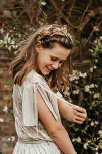 meisje met bloemenkroon speelt met de lintjes van haar mouw-vormsel-lentefeest-groeifeest-kinderfotografie-Fotografils-by Ilse Wagemakers-fotograaf-Essen