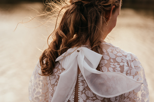 detail van strik op de rug waarin de wind speelt- foto genomen bij golden hour-communie-lentefeest-groeifeest-vormsel-kinderportret-by Fotografils-Ilse Wagemakers-fotograaf-Brasschaat