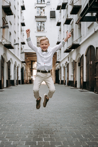 vrolijk springende jongen in een gaanderij-lentefeest-communie-groeifeest-portretfotografie-Fotografils-by Ilse Wagemakers-fotograaf-Antwerpen