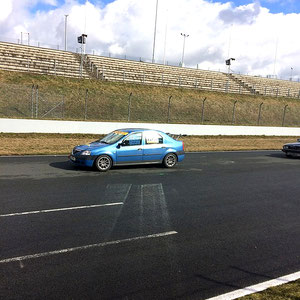 Gegen Mittag bei Sonnenschein, viel Wind und rasch abtrocknender Rennstrecke der Dacia Logan Cup Tourenwagen auf der Zielgeraden