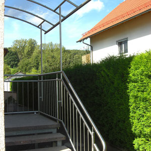 Edelstahl-Treppengeländer mit integrierten Vordachstützen
