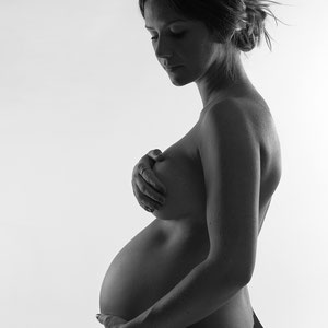grossesse femme enceinte qui pose en clair obscur maternité