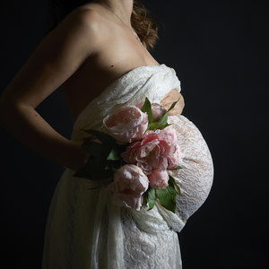 grossesse femme enceinte qui pose avec un bouquet de fleurs maternité