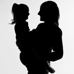 grossesse maternité femme enceinte qui pose avec sa fille en silhouette