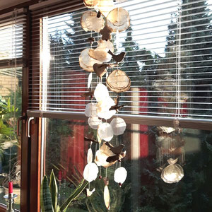 Gelbes Windspiel im Wohnzimmer als Fensterdekoration.