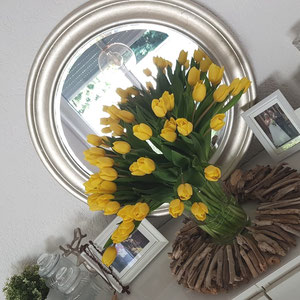 Treibholz Kranz in Brauntönen als Tischdeko, mit gelben Tulpen in der Kranzmitte.