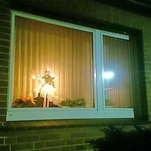 Leuchtstern beidseitg auf einem Metallständer im Fenster aufgestellt.