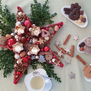 Roter Stern als Alternative zum Adventskranz mit Glaswindlichtern - Gewürzen - Glaskugeln mit Buxbaum und einer Teetasse auf grüner Tischdecke dekoriert.