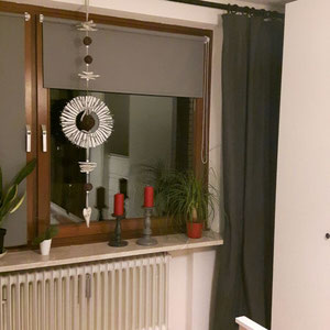 Weißer Naturkranz im Wohnzimmerfenster.