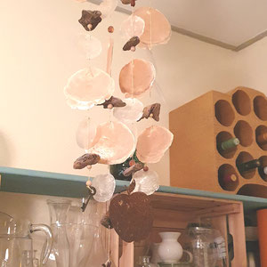 Windspiel in Orangetönen aus Capiz Muschelscheiben und Edelrost Elementen als Küchendekoration.