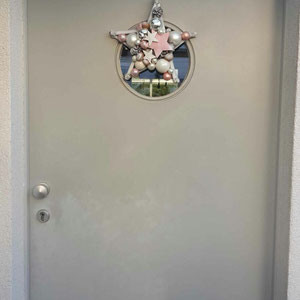 Kleiner 30 cm Stern in rosa-grau an der Haustür.