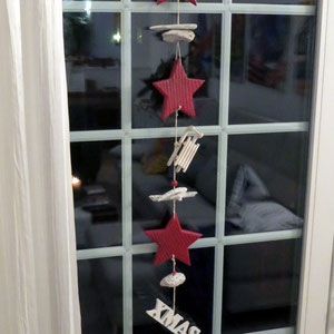 Weihnachtliche Fensterdekoration mit einer rot - weißen Girlande.