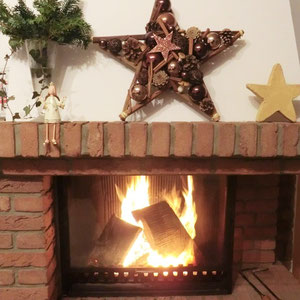 Deko Stern in braun-kupfer auf einem gemauerten Kamin.