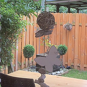 Dekokette aus Holzschmetterlingen und Rattanbällen auf der Terrasse aufgehängt.