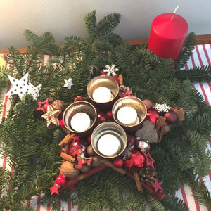 Adventskranzalternative: Tischstern mit roten Teelichtern stimmungsvoll mit Tanne dekoriert.