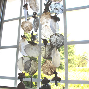 Windspiel als Sichtschutz aus silberfarbenen und weißen Capiz Muscheln.
