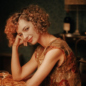 portrait couleur de la comédienne louise Bourgoin accoudé a une table sur un tournage de film d'époque