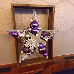 Violett - Silber Stern mit Schneeflocke als Hingucker - an einen Holz Dekorrahmen gehängt.