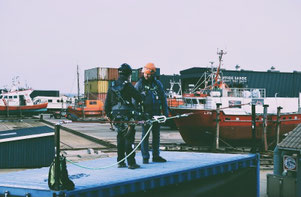 2 Personen stehen auf einem Container und sind an einer Lifeline gesichert