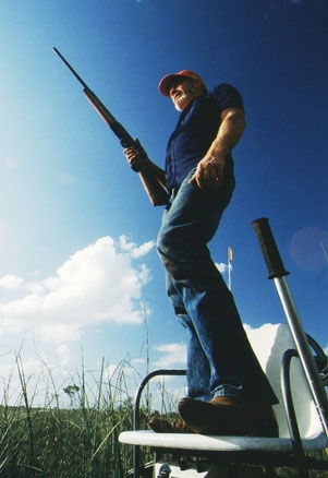 From his perch atop a swamp buggy, a 'Glades hunter scans the broad wetland for his prey; just outside Everglades National Park, Florida, USA.