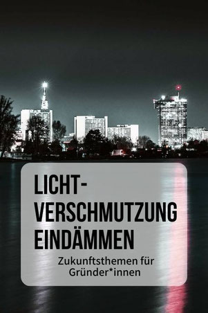 Hell erleuchtete Hochhäuser in Wien bei Nacht, im Vordergrund die Alte Donau