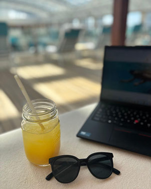 Orangensaft, Sonnenbrille und Laptop an Deck der EUROPA 2