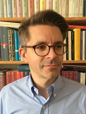 Das Bild zeigt den Übersetzer Tobias Schwartz vor einem Bücherregal.
