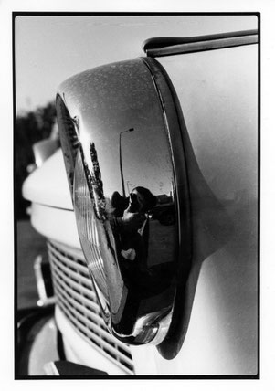 Selbstporträt des Fotografen als Spiegelung im Scheinwerfers eines Trabant im Jahr 1984.