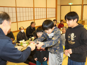 中津谷川自治会　新年会で参加した子どもたちにお年玉を渡す様子
