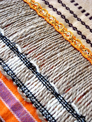 Close-up of  natural jute joining ribbon on orange, white and sandy striped, flat-weave, Indian cotton throw