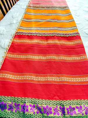 Three-piece, red, orange and pink striped, flat-weave, Indian cotton throw with natural jute and burgundy sequence joining ribbon and thick, floral, maroon and gold jari border with cream pom-pom trim