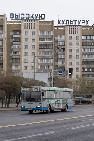 ソビエト共産団地を背に走るローカルバス