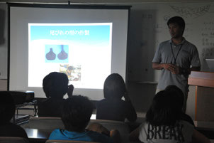 人工尾びれプロジェクトについて講話する古網主任