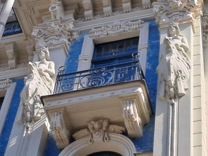 White stone sculptures of mythological figures riding eagles on facade of Art Nouveau building in Riga