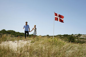 Dänemarks Nationalflagge weht gern in den Dünen – der Dannebrog auf Bornholm. Foto: VisitDenmark/Niclas Jessen