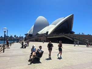 Sydney Opera House viewed from sothern forecourt with two joggers in foreground