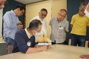 製作中の模型を説明する 講師と取り巻く受講者