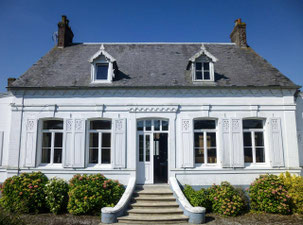 Façade blanche traditionnelle du Gîte Saint Lambert avec ses volets en bois, son escalier en pierre et ses hortensias fleuris sur la Côte d'Opale.