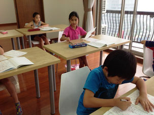 書道教室で小学生低学年の子が硬筆をしっかり学んでいる様子。