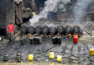 Un lavoratore prepara un distillato alcolico tradizionale, conosciuto localmente come "chang'aa", in una micro-fabbrica illegale di birra lungo il fiume nei sobborghi di Nairobi. 9 maggio 2014.