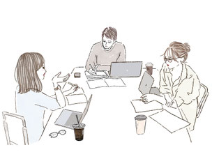 ノートパソコンと資料を広げてミーティングする男女。