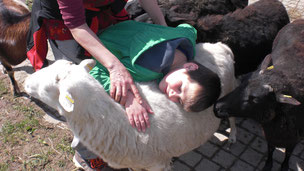 Kind, das mit einem Schaf kuschelt