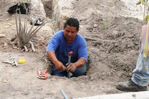Un técnico de la Epam hace una acometida domiciliaria en el Barrio Nuevo Manta 2. Manta, Ecuador.