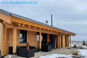 Winterbau - Holzblockhaus - Blockhausbau im Winter - Gartenanlage im Frühling