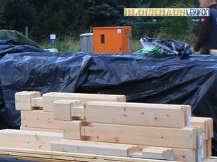 Blockhaus - Blockhausbau - Sortierte Blockbalken auf dem Fundament - Holzschutz - Eigenleistung - Bausatzhaus - Blockhaus Bausätze - Wohnblockhäuser - Ratgeber - Erfahrungen - Holzbau - Neubau - Handwerker bei der Arbeit in Brandenburg - Ausbauhaus