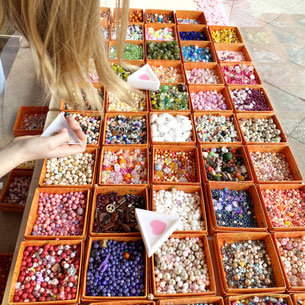 Kinder basteln fröhlich Armbänder beim Workshop mit dem ELA EIS Perlenkonfetti