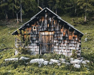 Rustikale Berghütte aus Holz am Wanderweg im Salzkammergut, umgeben von Wald und Wiesen